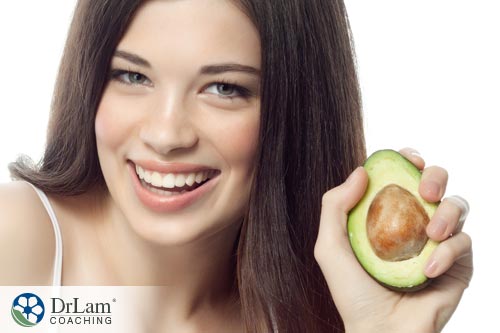 Young healthy girl holding an Avocado health benefits in her hand