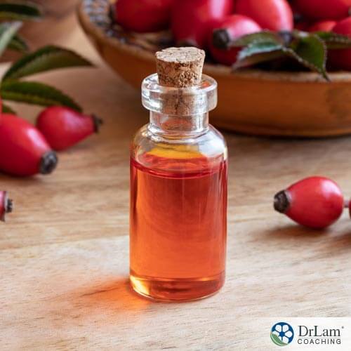 bottle of rose hips extract on a table with rose hips