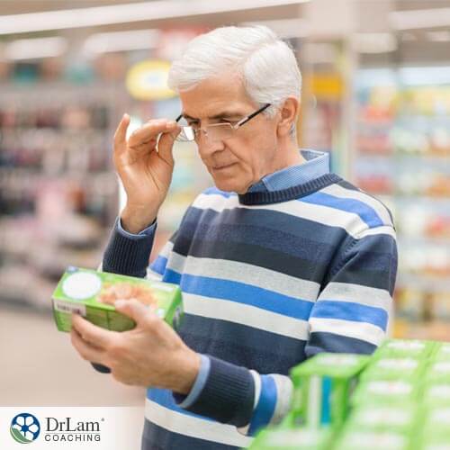 An older man reading the nutrition label cheat sheet to make a healthy decision