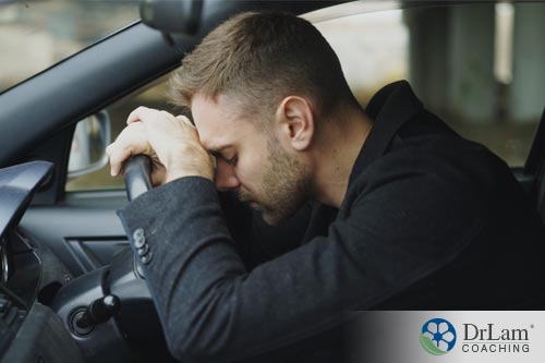 Man slouched over on the steering wheel and may benefit from more cortisol vs cortisone