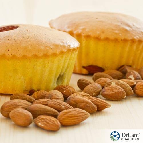 Almonds on a table with muffins to show that they are almond flour muffins