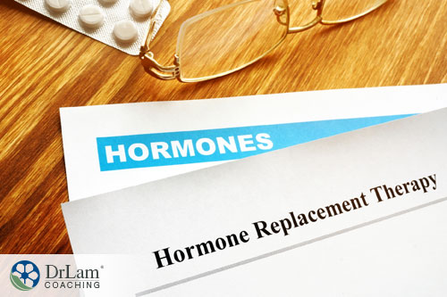 An image of hormone replacement therapy documents on a table with reading glasses and a blister pack of pills
