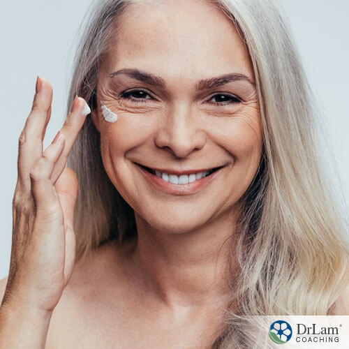An image of an older woman applying a skincare product to her face
