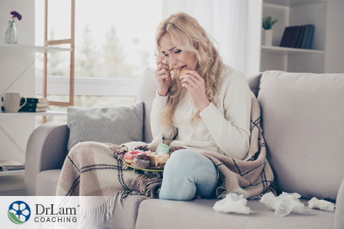 An image of a stressed-out woman binge eating unhealthy food