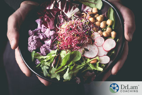 An image of a salad bowl containing chickpeas, red cabbage, purple cauliflower, radishes and salad greens
