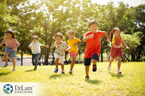 An image of children running and smiling in the sun together