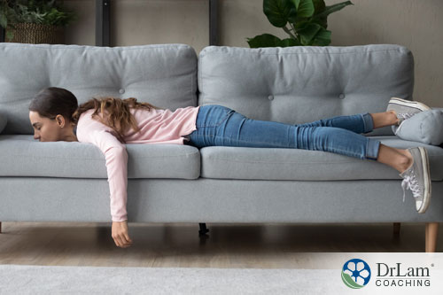 An image of a fatigued woman laying on the couch