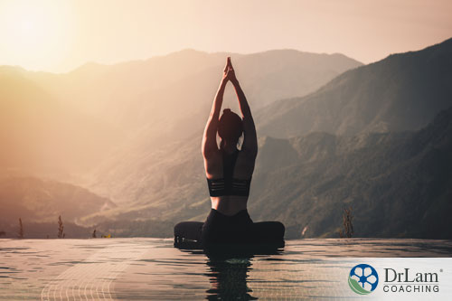 An image of a woman doing a yoga pose with mountains in the background