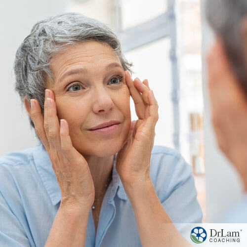 An image of an older woman looking at her eyes in the mirror