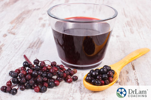 An image of elderberries and a glass of elderberry juice