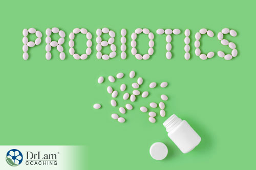 An image of spilled out pills spelling out probiotics on a green background