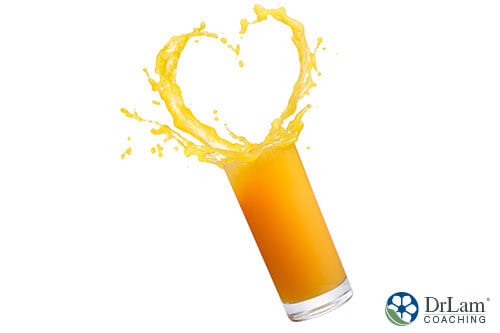 An image of a glass of orange juice splashing out into a heart shape