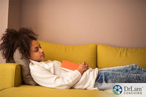woman lying on the couch relaxing and enjoying the stress-reducing benefits of reading
