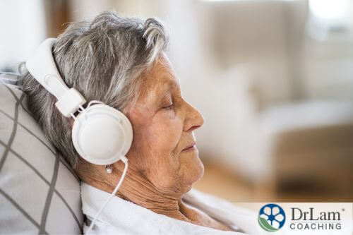 An image of a older woman wearing headphones and relaxing