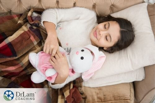 An image of a little girl sleeping with her stuffed rabbit toy