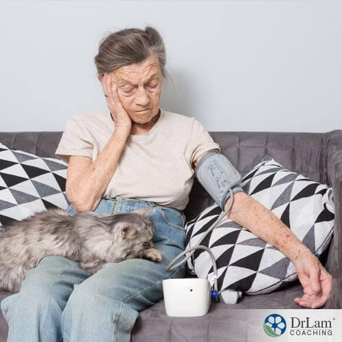 An image of an older woman on the coach who has low blood pressure and fatigue which are adrenal exhaustion symptoms