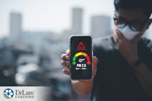 An image of a man testing the air quality index with his phone