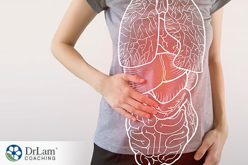 woman holding her stomach with image of the digestive system