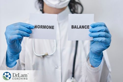 An image of a woman holding papers with hormone balance on them