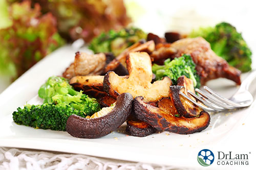 An image of cooked shiitake mushrooms with broccoli on a plate