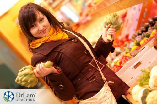 An image of a woman holding an artichoke