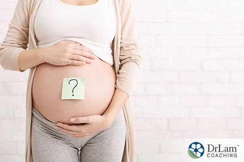 An image of a pregnant woman holding her stomach with a question mark on it