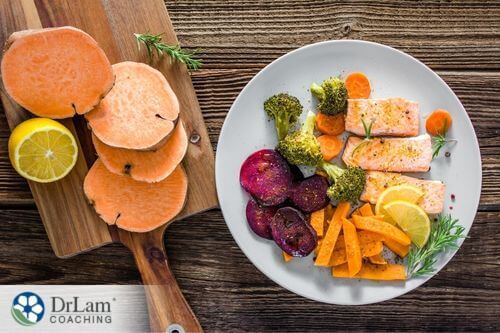 An image of salmon and cooked veggies on a plate