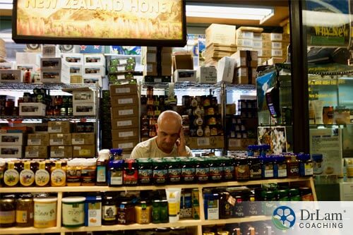 An image of a stressed-out man in a store looking for bee products to help him with his stress