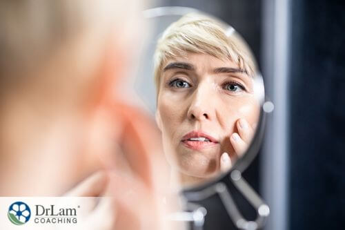 An image of a woman looking in a mirror at her face