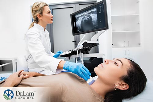 An image of a doctor preforming an ultrasound on a woman's thyroid