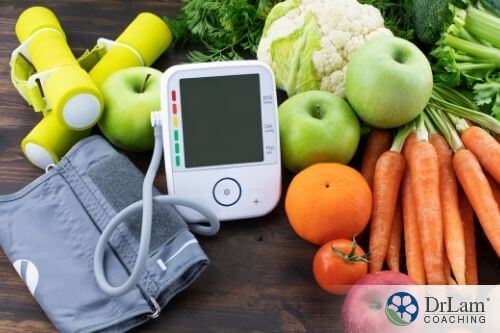 An image of a digital sphygmomanometer with various fruits and vegetables around it