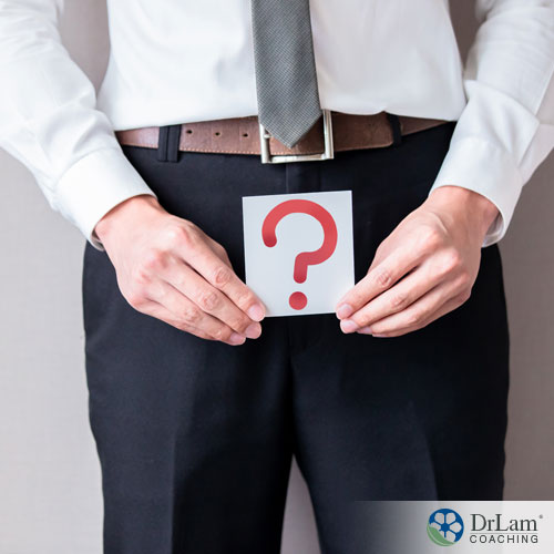 An image of a man holding a question mark in front of his pelvis