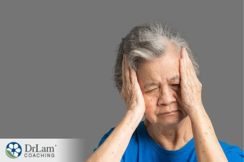 An image of a older woman holding her head