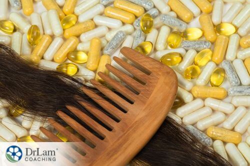 An image of a lock of hair on a comb with supplements behind them