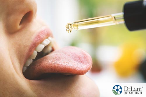 An image of a woman dropping CBD oil on her tongue