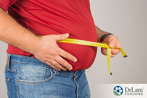 an image of a fat person measuring his belly
