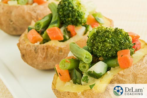 An image of baked potatoes stuffed with broccoli, green beans and other vegetables