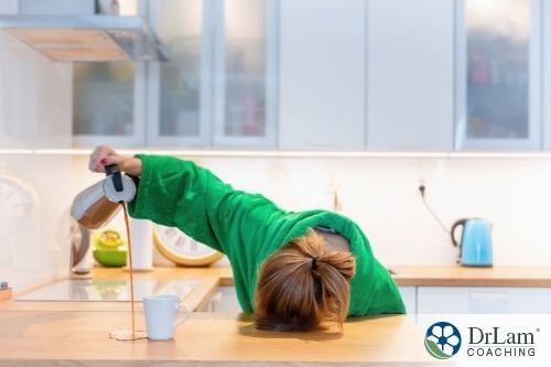 An image of a woman with her head on the counter spilling coffee