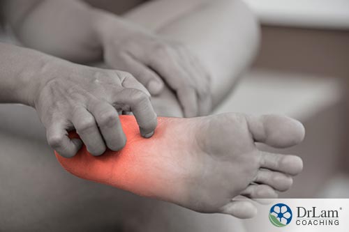 An image of someone itching their inflamed foot