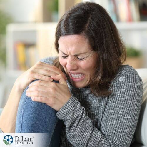 An image of a woman hugging her knee in pain