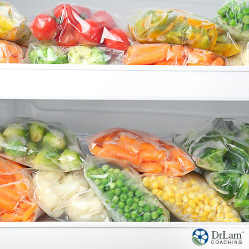 An image of various kinds of frozen vegetables in plastic bags stacked in the freezer