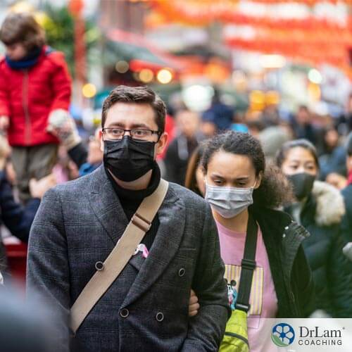 An image of people wearing masks walking in a crowded street