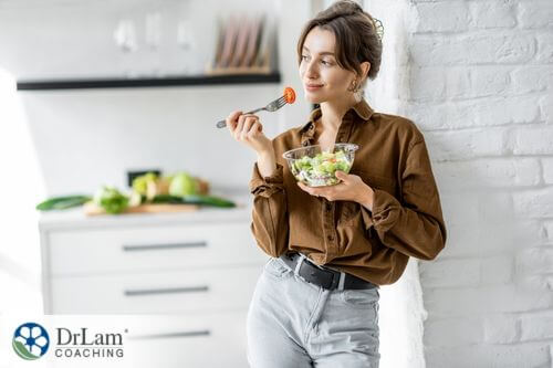 An image of a woman eating a salad