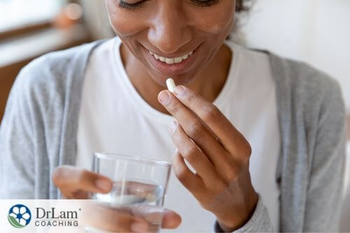 An image of a woman taking a supplement
