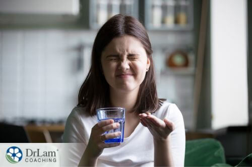 An image of a young woman taking a supplement