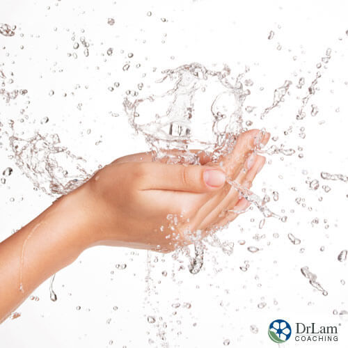 An image of water splashing into a womans hands