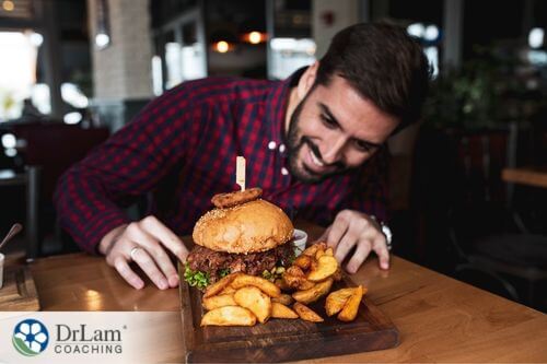 An image of a man with a hamburger and fries