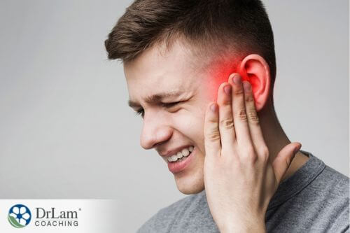 An image of a man holding his inflammed ear