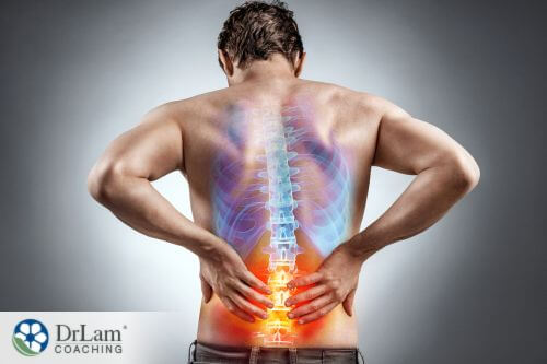 An image of a man holding his inflammed lower back