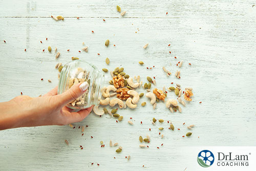 An image of a woman sprinkling mixed seeds and nuts on a table